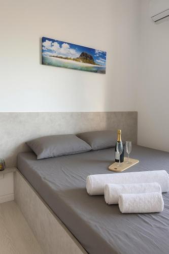 a bed with two towels and a table with wine glasses at Suite Sky and Sea in Flic-en-Flac