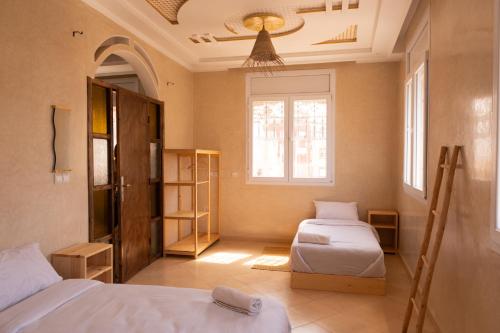 a bedroom with two beds and a window at Surf & bask HOME in Tamraght Ouzdar
