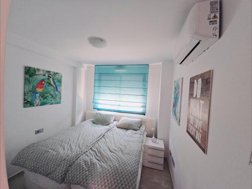 a small bedroom with a bed and a window at Cozy, modern, two-level apartment in Orihuela Costa