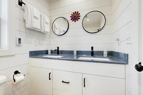 a bathroom with two sinks and two mirrors at Trails & Tranquility in Pagosa Springs