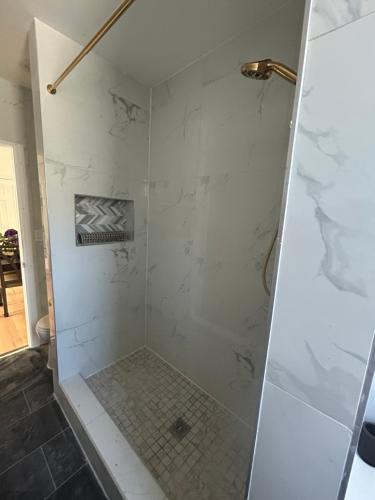 baño con ducha de mármol blanco en Cozy modern Bellerose, en Bellerose
