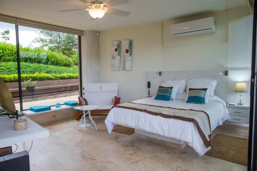 a bedroom with a bed and a large window at Hotel Casa Ambrosia in Villeta