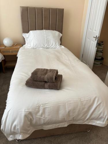 a bed with a towel on top of it at Crescent Corner 44 Seamore Str Ground Floor Right in Largs