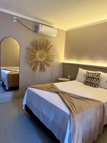a bedroom with a large bed and a mirror at DECK DOS LENÇÓIS pousada in Barreirinhas