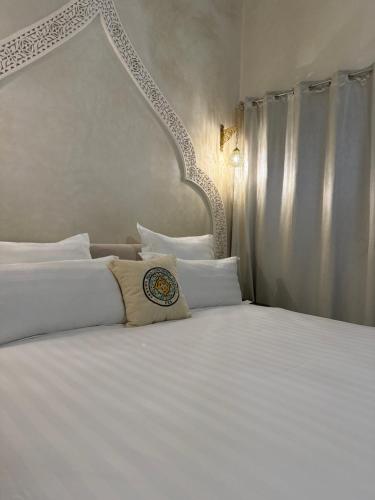 a bedroom with a large white bed with white pillows at Riad Citronnier & Spa in Fès