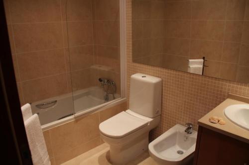 La salle de bains est pourvue de toilettes, d'une douche et d'un lavabo. dans l'établissement Apartamentos Mar de Alvor, à Alvor