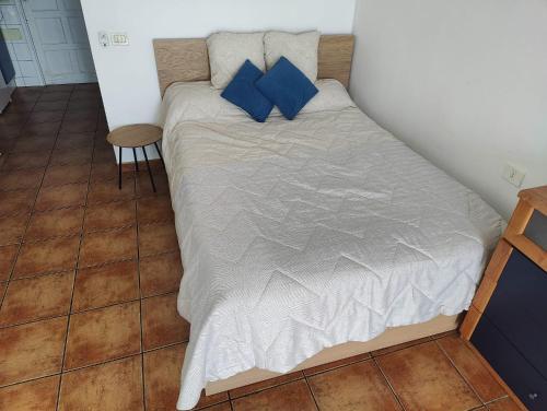 Cama en habitación pequeña con almohadas azules en The sea balcony, en San Marcos