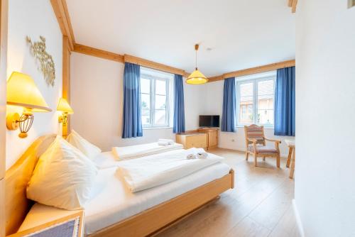ein Schlafzimmer mit zwei Betten, einem Schreibtisch und einem Stuhl in der Unterkunft Hotel Krug in Gumpoldskirchen