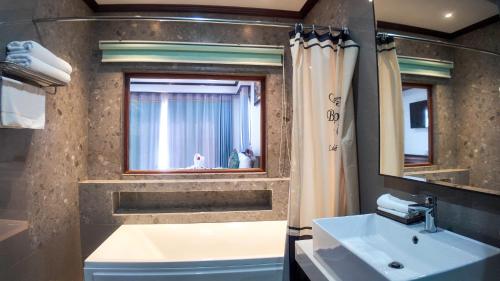 a bathroom with a sink and a window at Lodge Moni Essara Kampot in Kampot
