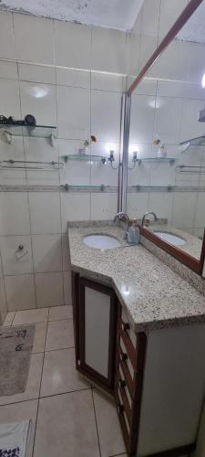a bathroom with two sinks and a mirror at Centro de Florianópolis praça XV in Florianópolis