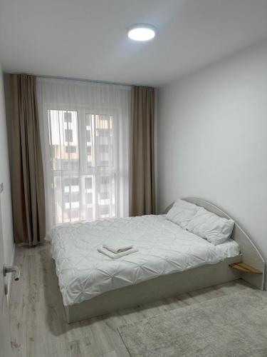 a bed in a bedroom with a large window at Apartament panoramic in Bistriţa