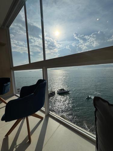 a view of the ocean from a window with two chairs at Refúgio da Lagoa azul in Angra dos Reis