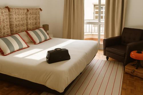 una camera d'albergo con un letto con una borsa nera sopra di Teatro View a Fundão