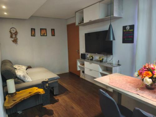 a living room with a couch and a flat screen tv at Apartamento aconchegante 10 minutos de Penedo in Resende
