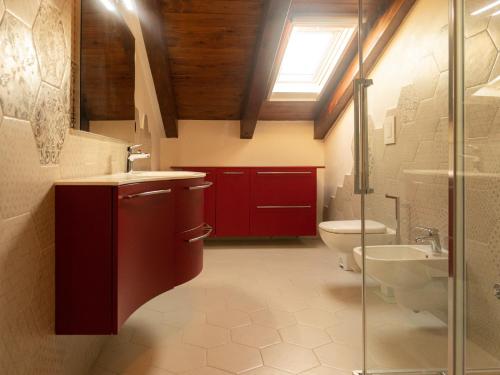een badkamer met rode kasten, een wastafel en een toilet bij Gran Caffè Bed in Castrovillari
