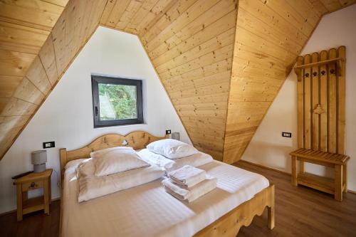 a bedroom with a bed with a wooden ceiling at A Frame Chalet By Superski in Cavnic