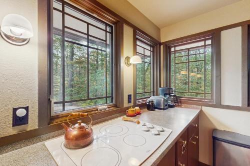 a kitchen with a tea kettle on a counter with windows at The Frank Lloyd Wright Home @ Deep Creek, MD in Bittinger