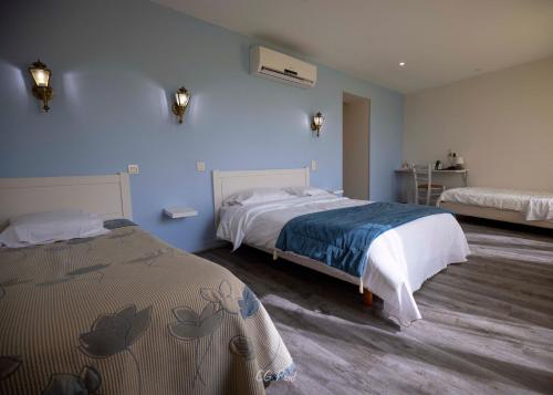 a bedroom with two beds with blue walls at Les Ambassadeurs Logis Hotels et Restaurant in Souillac
