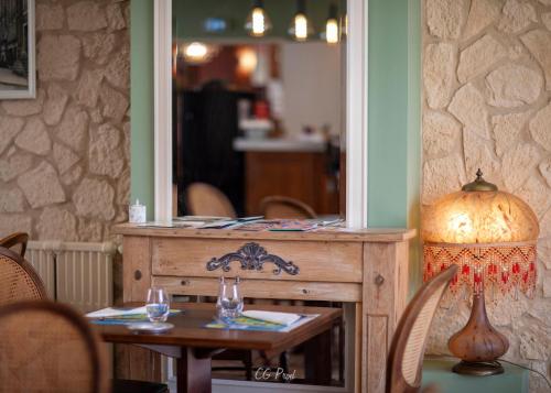 Les Ambassadeurs Logis Hotels et Restaurant في سويلاك: طاولة عليها مرآة وطاولة عليها مصباح