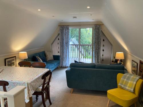 a living room with a blue couch and a table at Sue's Lodge in Cawsand