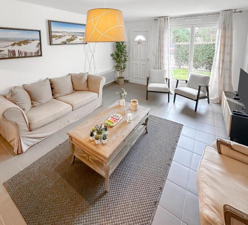 a living room with a couch and a coffee table at Un Temps Pour Nous - Downtown house near beach in Cucq