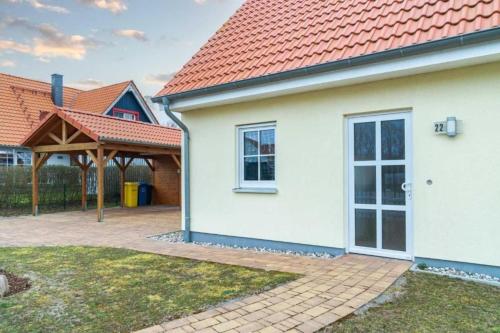 a white house with a red roof and a pavilion at Ferienhaus Rerik Piratenlager in Rerik