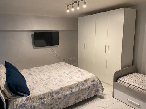een slaapkamer met een bed, een kast en een televisie bij A Casa Di Laura B&B Apartments in Campagna