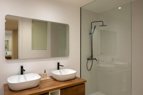 a bathroom with two white sinks and a shower at Villa Joy, moderna e sofisticada in Funchal