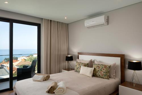 a bedroom with a bed with a large window at Villa Joy, moderna e sofisticada in Funchal