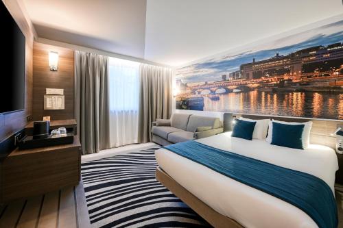 una habitación de hotel con una cama grande y un sofá en Novotel Paris Centre Bercy, en París