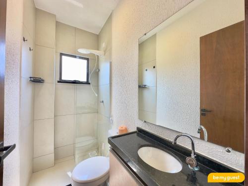 a bathroom with a sink and a toilet and a mirror at Beachfront Duplex B por Be My Guest in Aquiraz