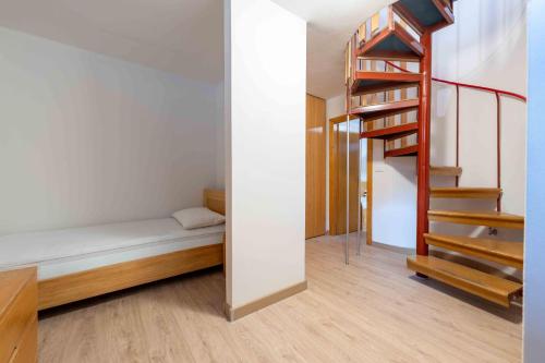 Cette petite chambre comprend un lit et un escalier. dans l'établissement Cesa Agnol, à Campitello