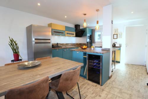 een keuken met blauwe kasten en een houten tafel bij Le CapriBeach by TAH - Top emplacement & Parking in Pornichet