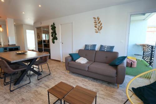 una sala de estar con un sofá y una mesa en Le CapriBeach by Tranquil at Home, en Pornichet
