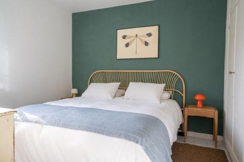 a bed in a bedroom with a green wall at La Casita de la Playa Escondida in Tal
