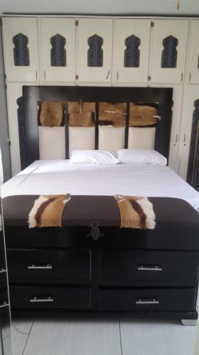 a bedroom with a large bed with a black frame at B and B Sunblue in Durban