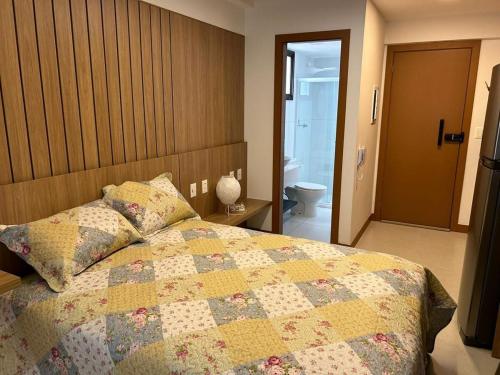 Un dormitorio con una cama con una colcha encima en Studio Barra Salvador -, en Salvador