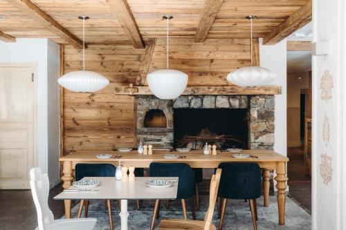 Un comedor con mesa y sillas y chimenea. en Hôtel des 2 Gares, en Saint-Gervais-les-Bains