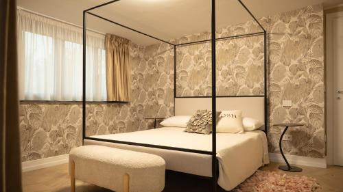 a bedroom with a four poster bed with a chair at Domino Suite House in Striano