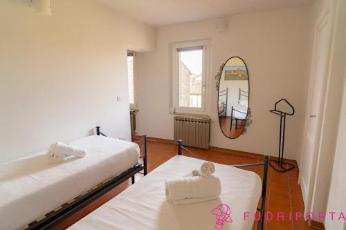 two beds in a room with a mirror at Tetti di Parma in Parma