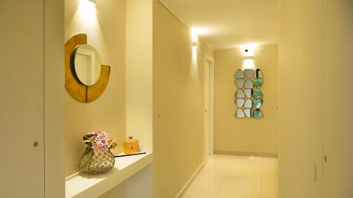a hallway with a vase on a shelf and a mirror at Domino Suite House in Striano