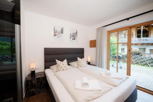a bedroom with a large white bed with white pillows at AlpenPura - Chalet mit Sauna und Panoramablick in Neukirchen am Großvenediger