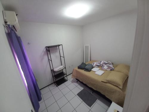 フォルタレザにあるApartamento Econômico e Aconchegante de 2 quartosのベッドと鏡のある小さな寝室