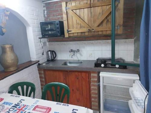 Una pequeña cocina con fregadero y microondas. en Complejo Villa del sol, en Mina Clavero