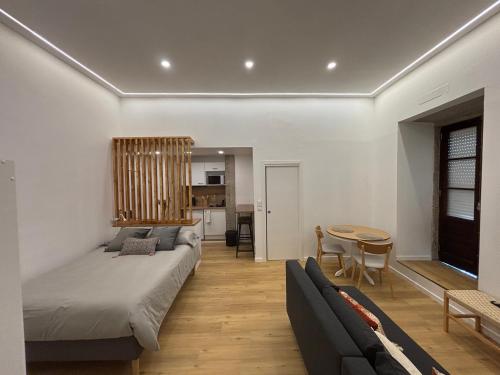 a living room with a bed and a table at Villa Matriz Suite Apartment in Caminha
