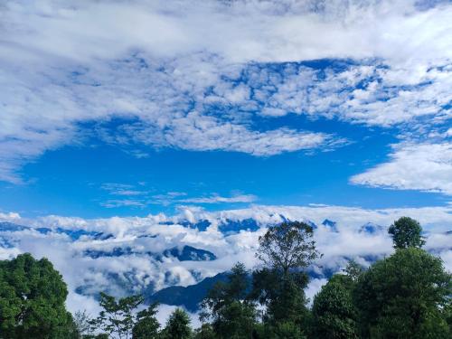 een uitzicht op wolken en blauwe lucht met bomen bij Zhim khang in Sosing
