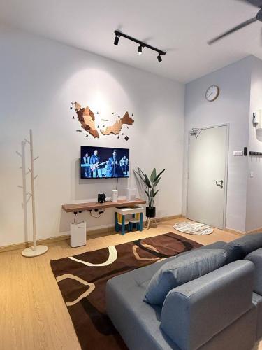 een woonkamer met een bank en een flatscreen-tv bij Suithauz Studio in Kuantan