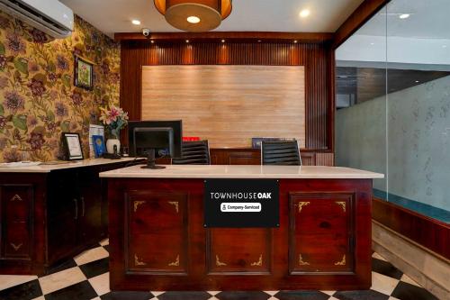 an office with a desk with a sign on it at Townhouse Oak Sahastradhara Road Dehradun in Dehradun