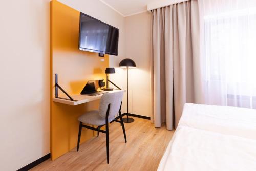 Una televisión o centro de entretenimiento en Garner Hotel Cologne East by IHG