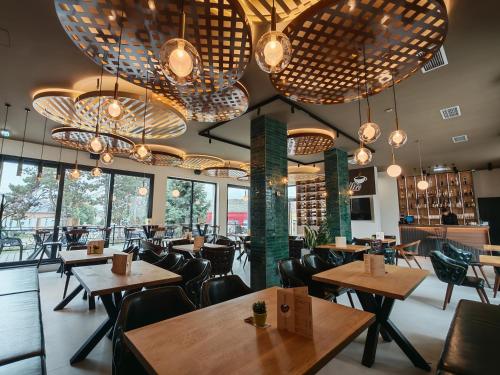 a restaurant with tables and chairs and large chandeliers at POOL RESORT Vila Lena - Lux residence apartman 1 in Vrdnik